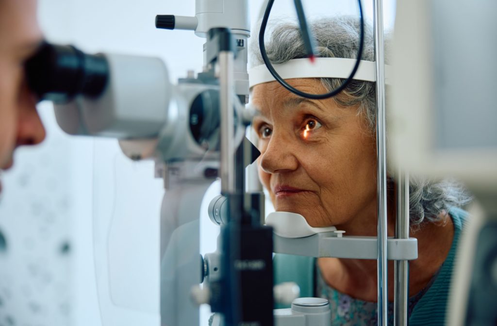 An optometrist examines their patient's eye using a slit lamp during a routine eye exam.