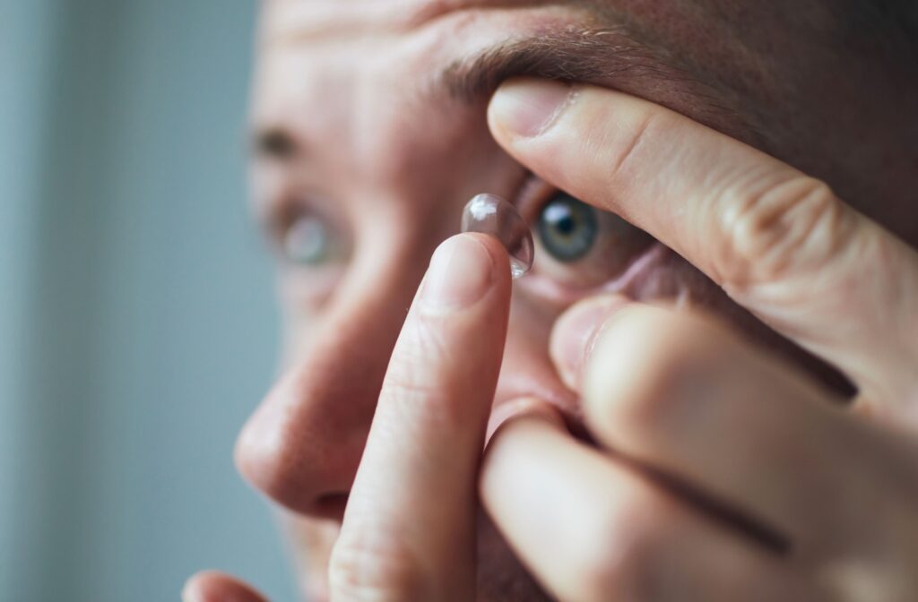 A person carefully inserting a soft toric contact lens.